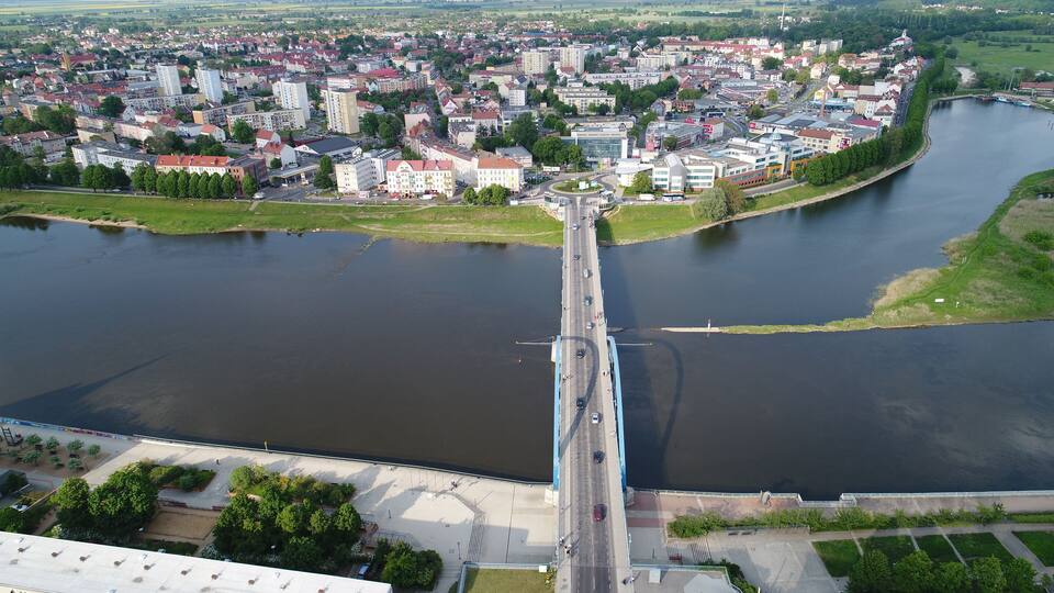A river with a bridge connecting two sides of a town.