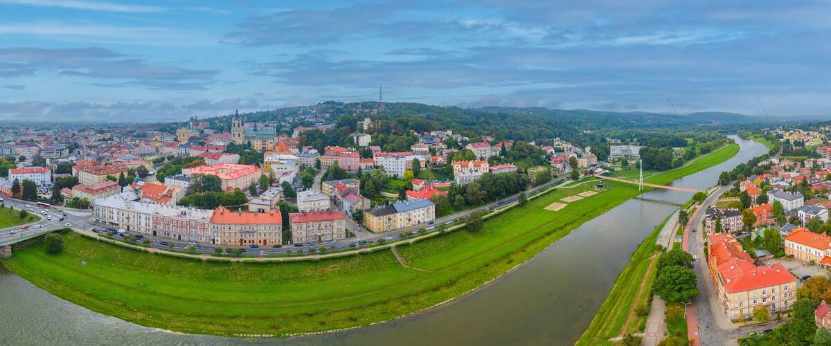 A river winding through a town with historic buildings and a bridge.