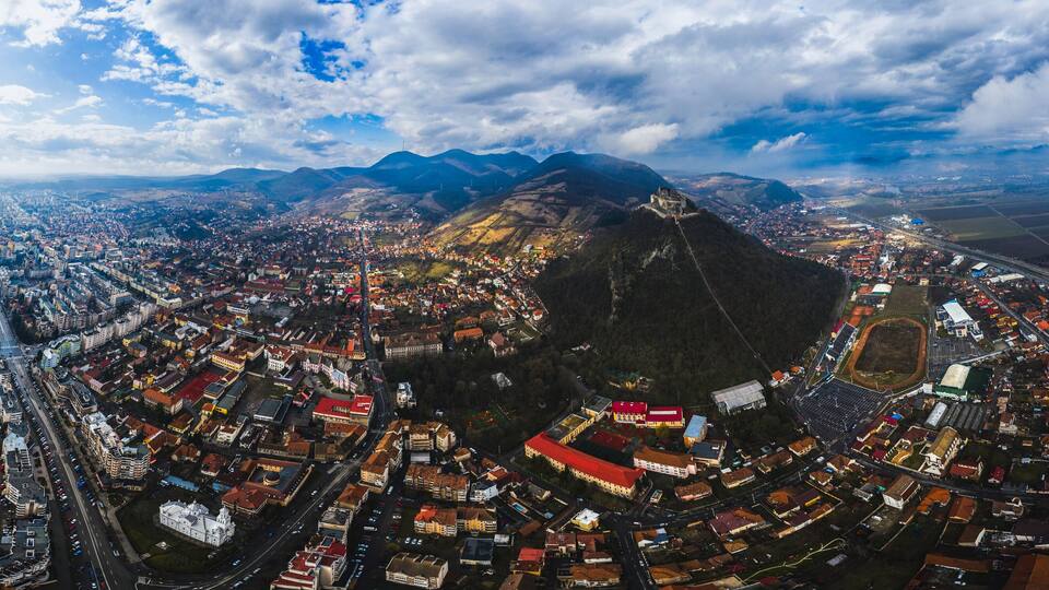 A panoramic view of a city with a prominent mountain in the background.