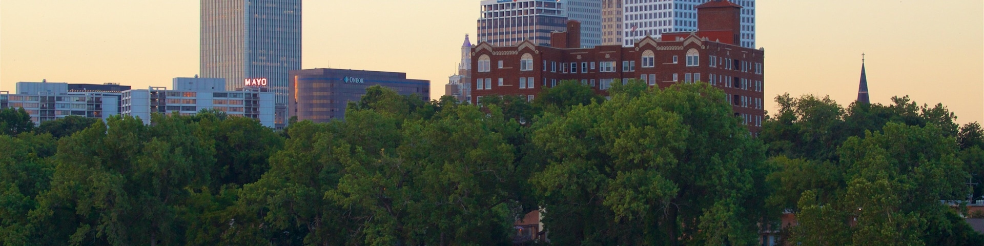 Tulsa which includes a high rise building, a sunset and a lake or waterhole