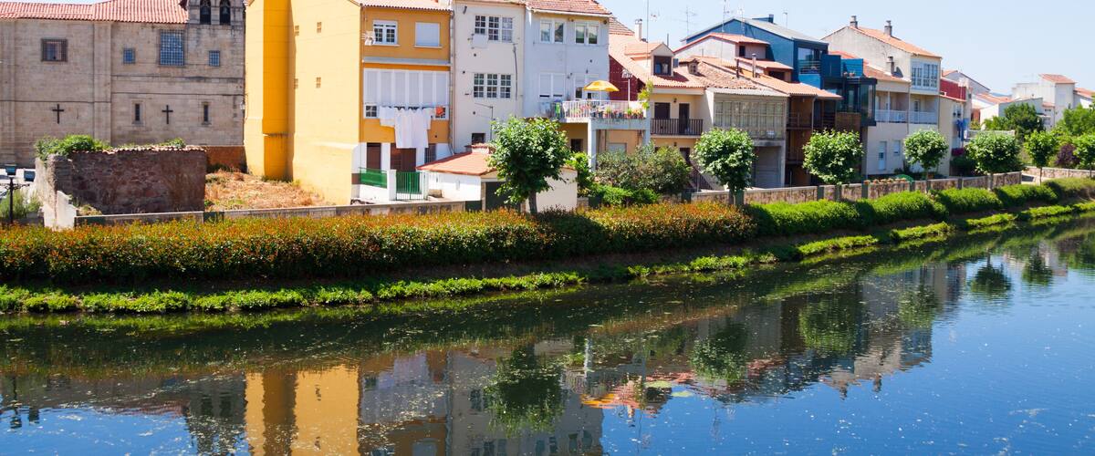 A canal with buildings reflecting on the water.