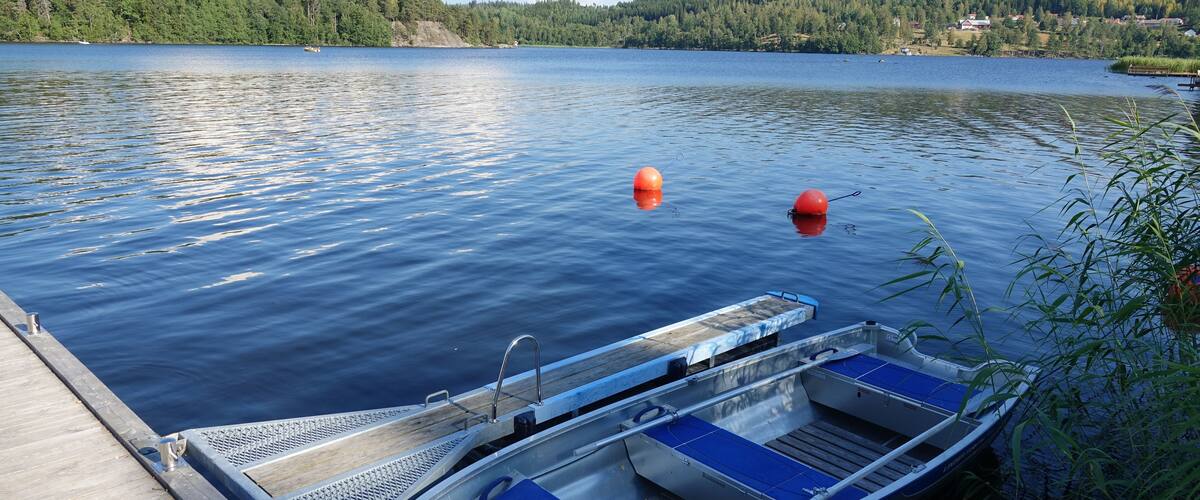 A calm lake with a dock and a small boat.