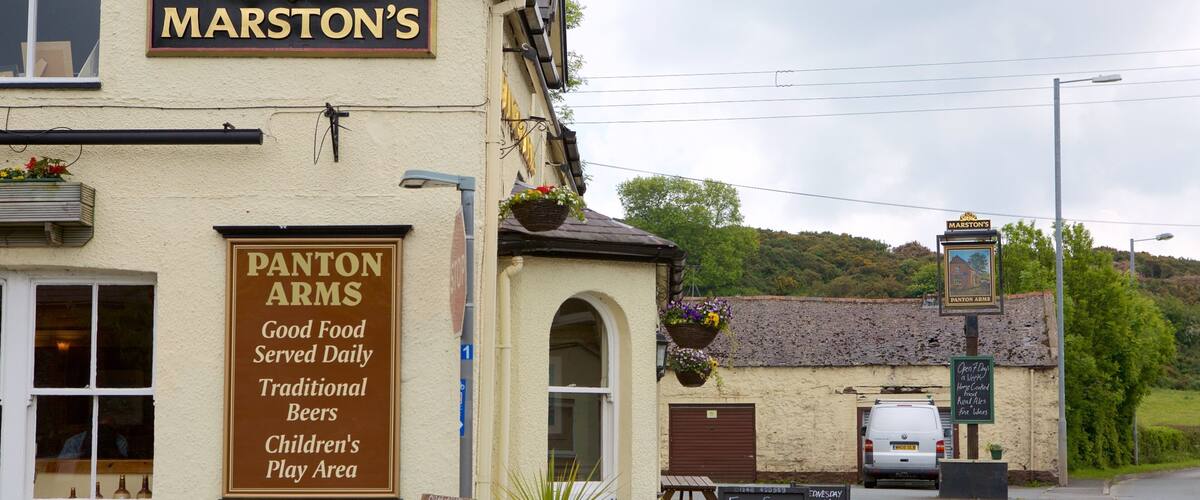 A building with signs for 'Marston's' and 'Panton Arms' offering traditional beers and a children's play area.