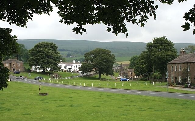 Bainbridge green Village stocks in the left foreground. The white building is the Rose & Crown Hotel.