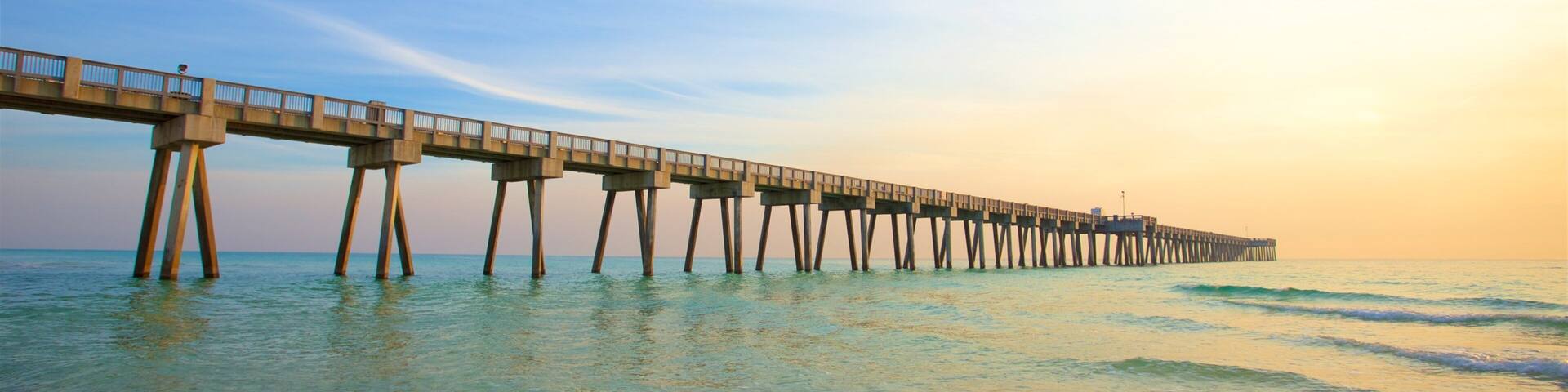 A pier extending into the ocean with clear skies.