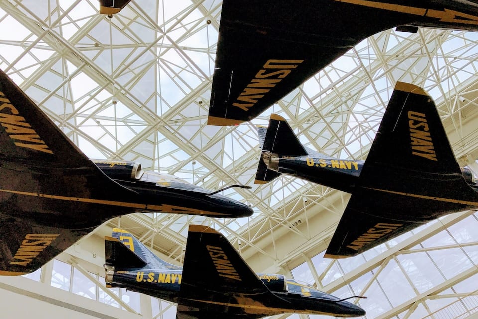 Vier US-Navy Flugzeuge in einem Gebäude mit Glasdach.