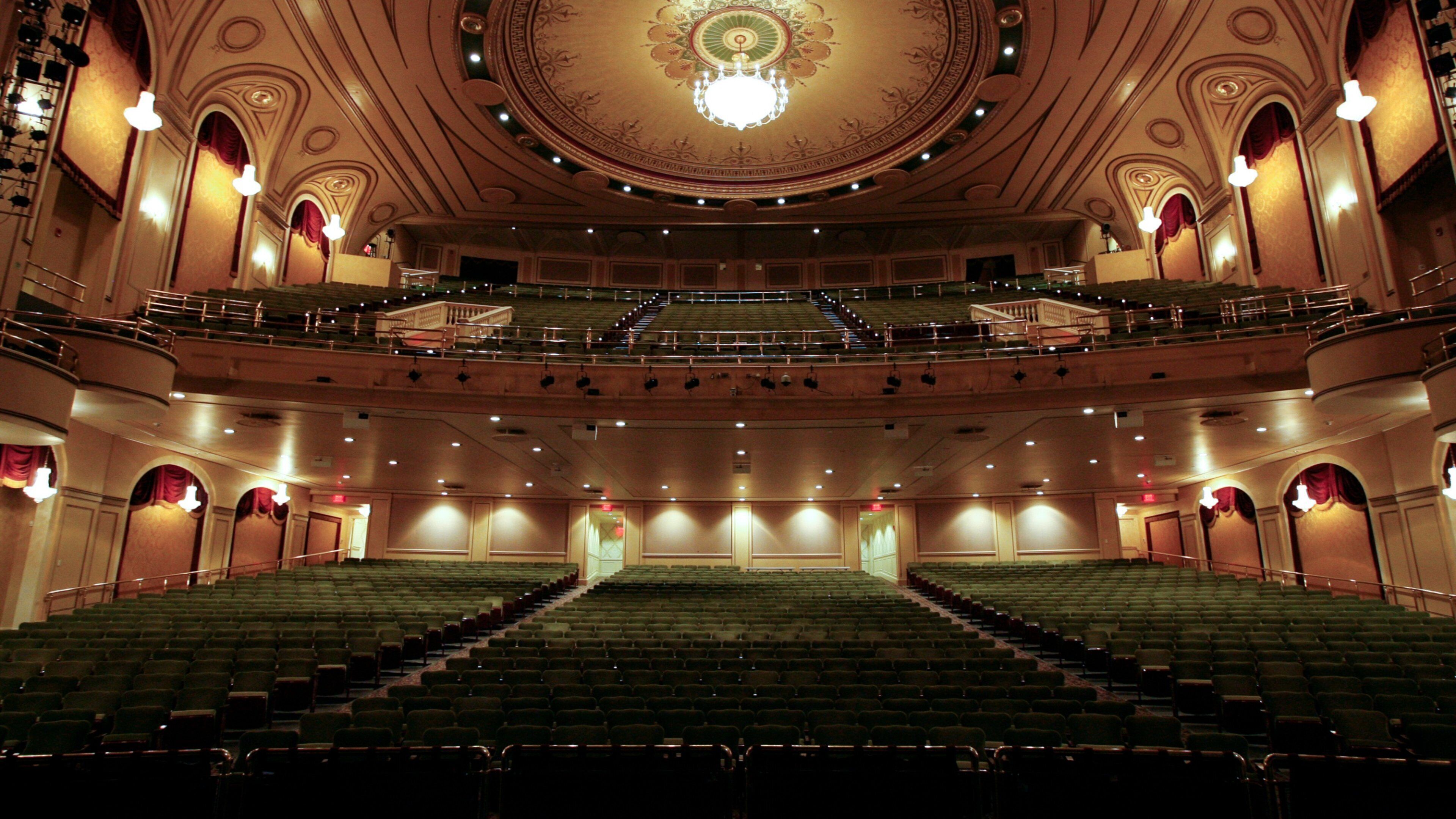 A grand theater with ornate architecture, multiple balconies, and rows of seats.