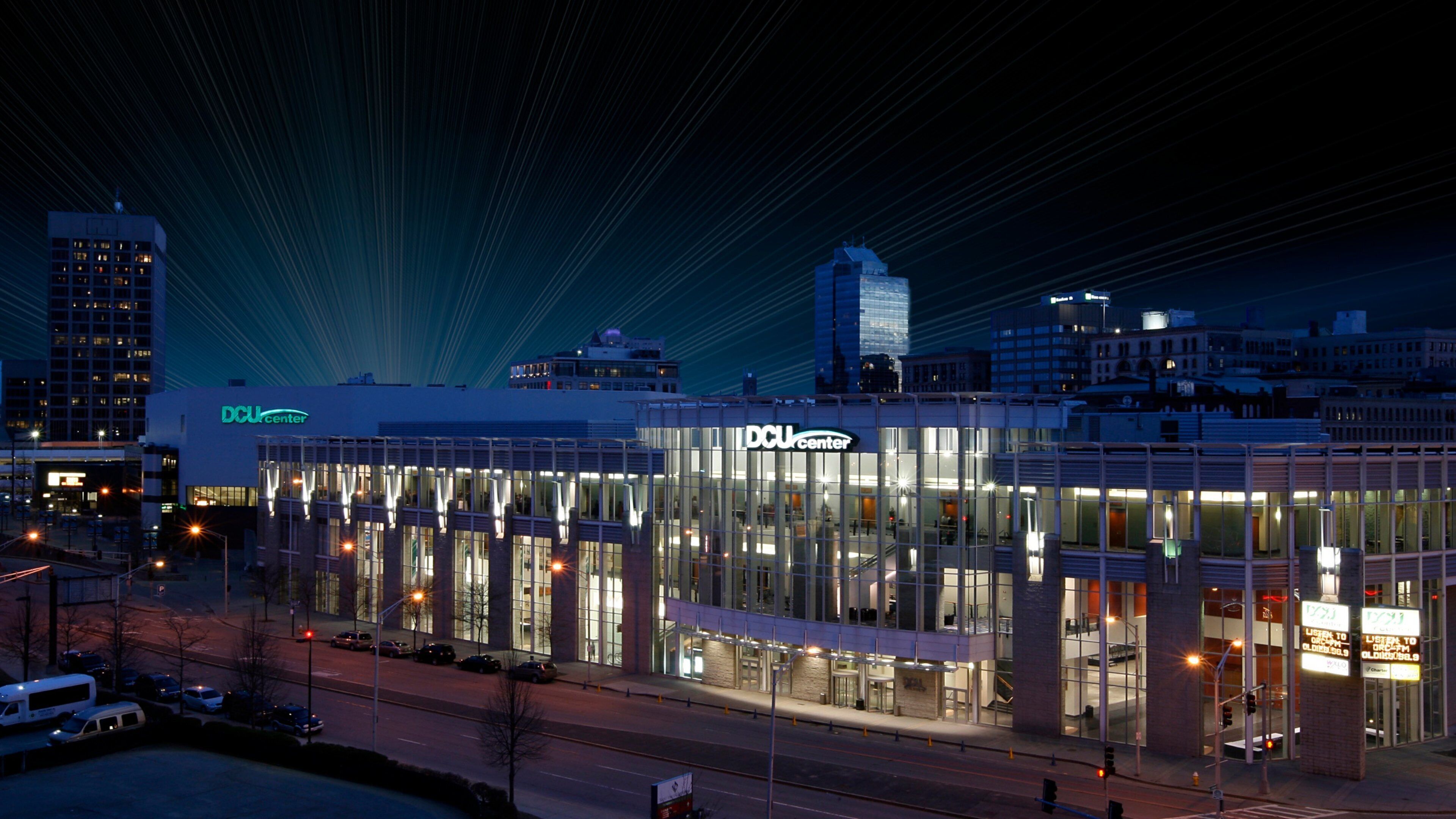 A modern building with the sign "DCU Center" at night.