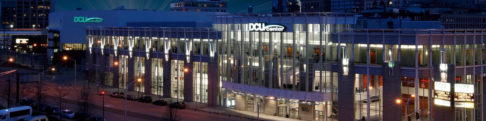 A modern building with the sign "DCU Center" at night.