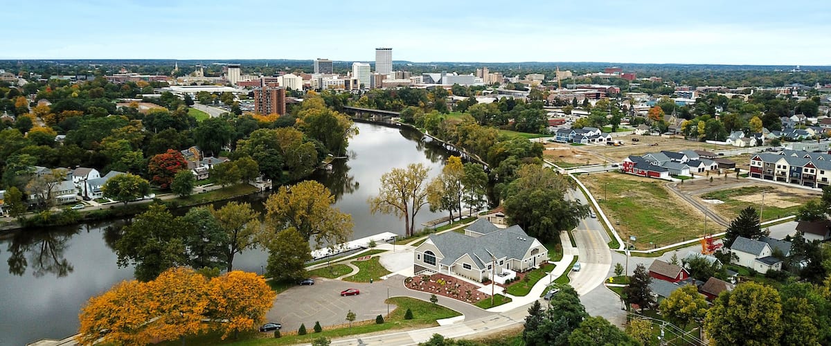 A river, residential houses, and a bridge in a suburban area.