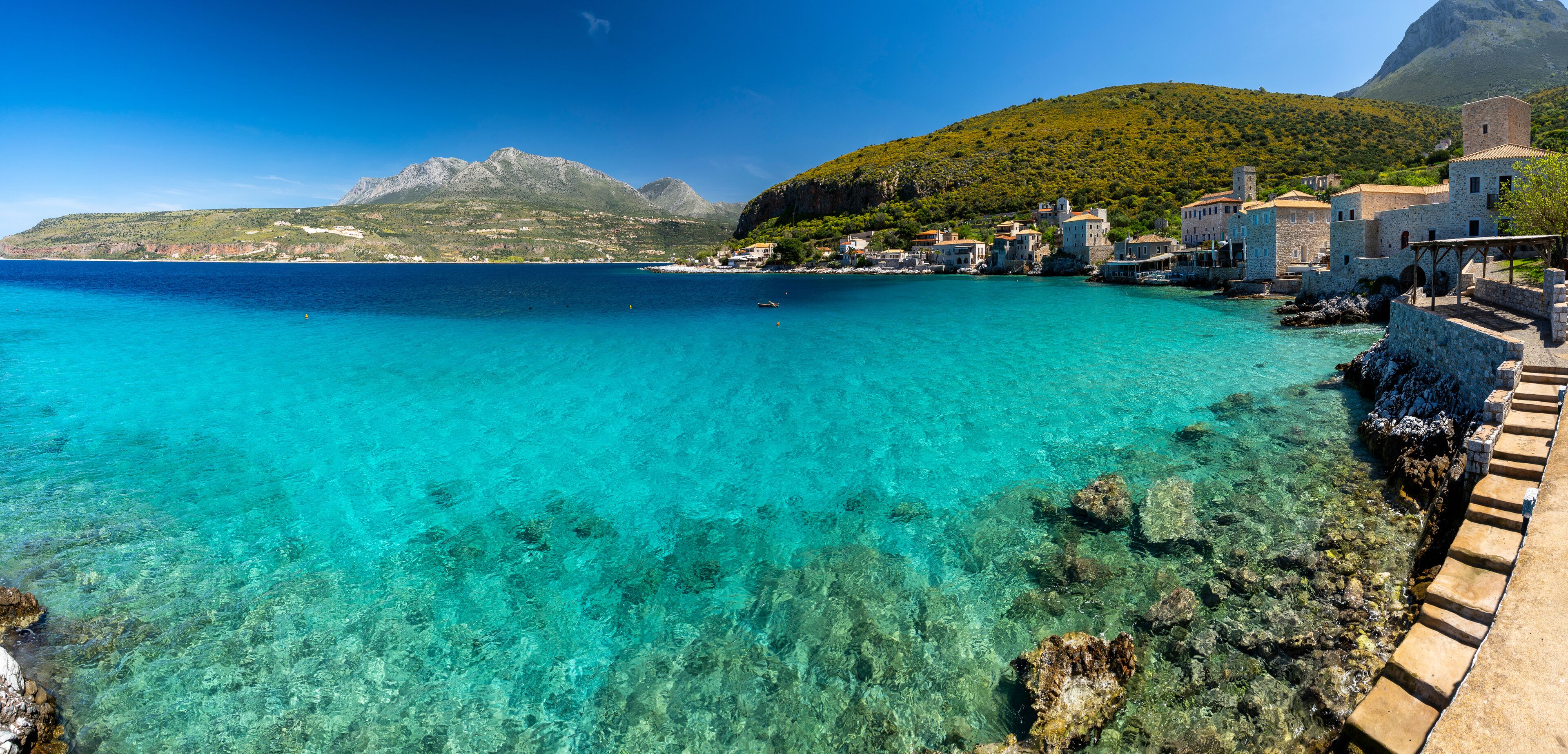 Greece, Mani Peninsula, Laconia, Limeni - 3 April 2024 - Overview of Limeni village and the turquoise sea surrounded by green nature