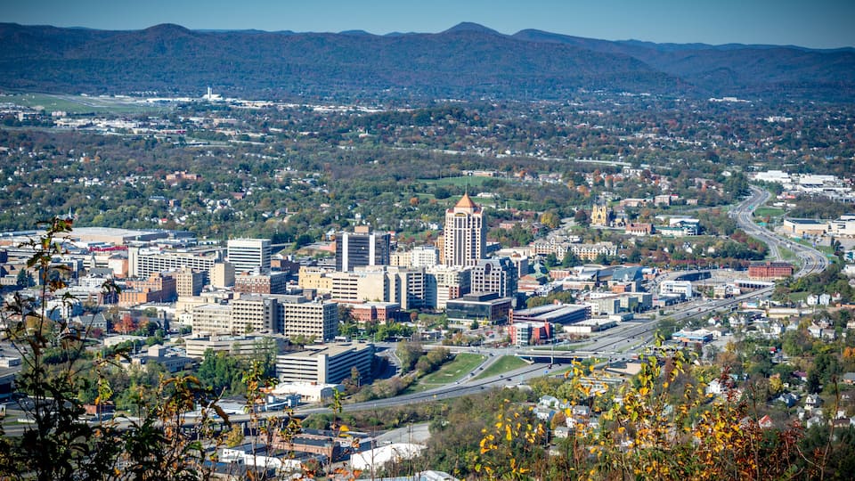 A cityscape with a prominent tower, a river, and surrounding hills.