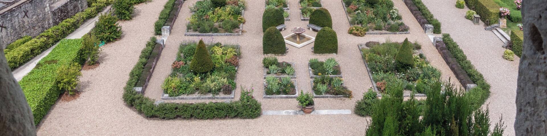 A large castle with a well-maintained garden and a moat.