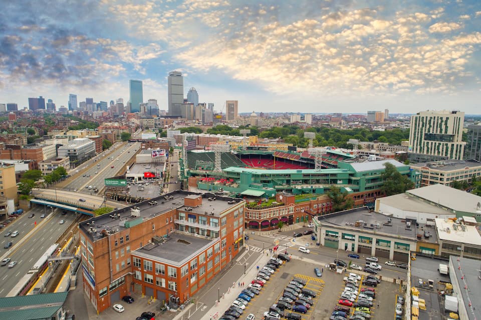 A cityscape with a prominent stadium, a busy intersection, and a skyline with high-rise buildings.
