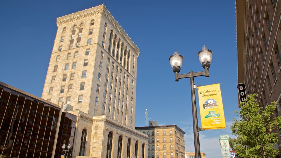 A tall building with arched windows, a street lamp, and a banner for Saginaw Pride.