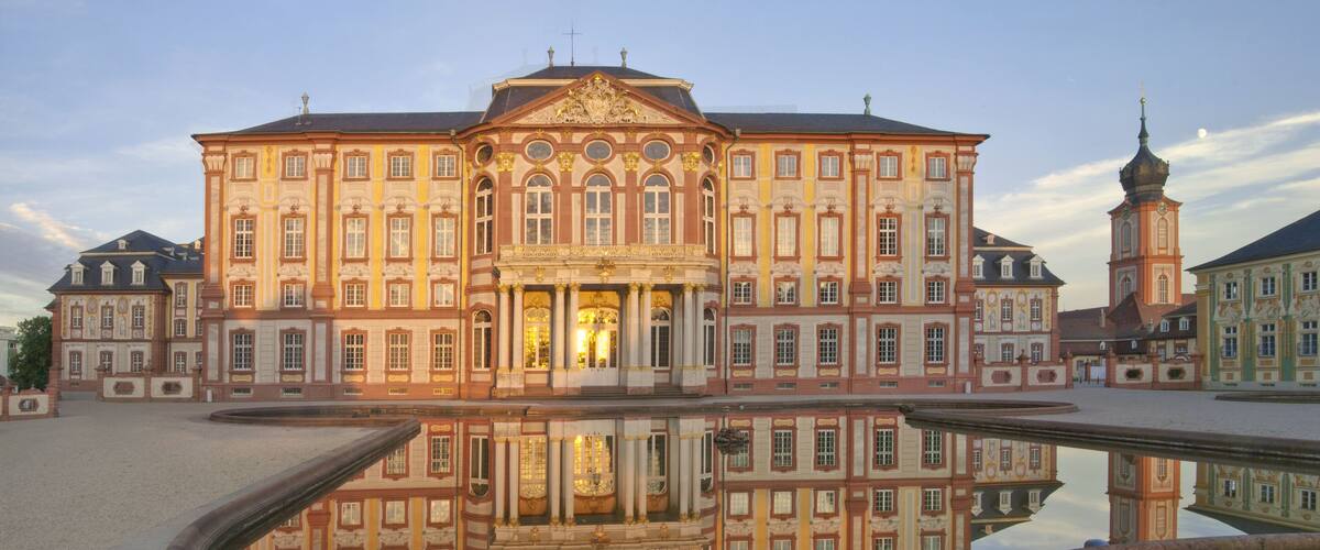 A grand historic building with a central courtyard and a reflecting pool.