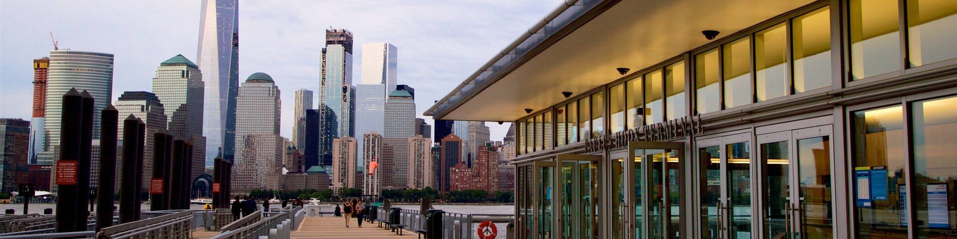 A waterfront walkway with a city skyline in the background.