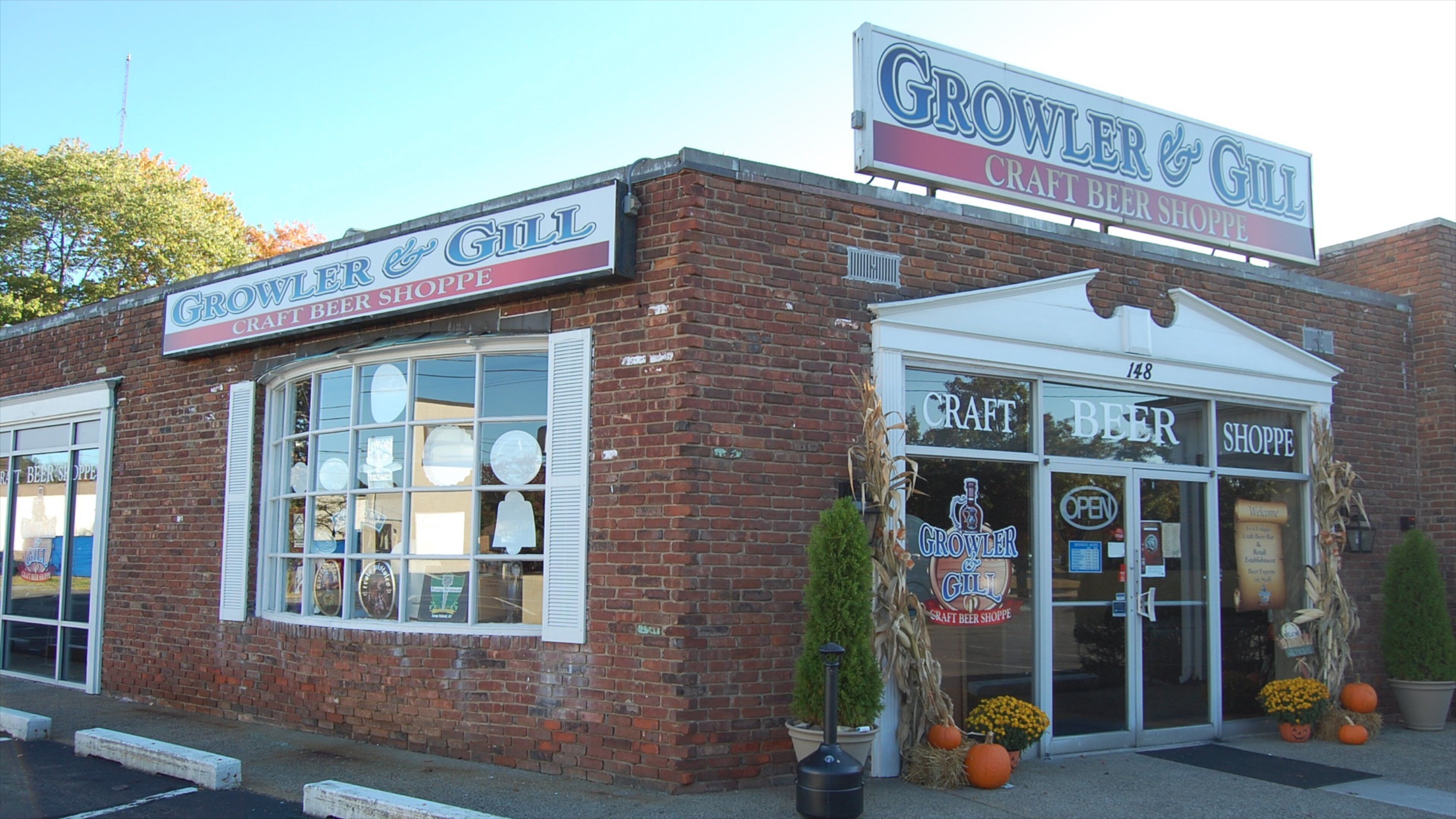 A brick building with a sign reading "Growler & Gill Craft Beer Shoppe".