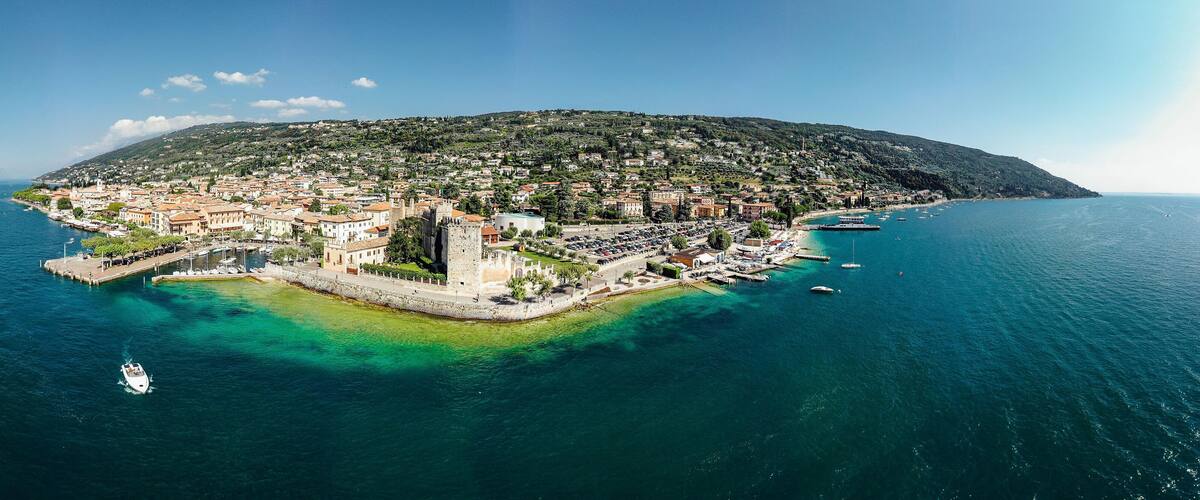 Drone shot of Lago di Garda lake in Italy with a view of the Torri del Benaco comune