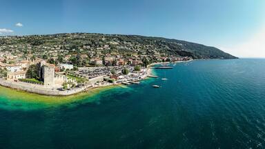 Drone shot of Lago di Garda lake in Italy with a view of the Torri del Benaco comune