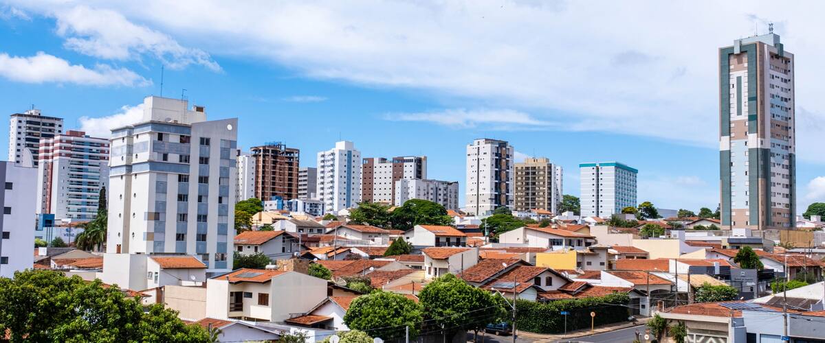 A cityscape with a mix of residential and high-rise buildings under a partly cloudy sky.
