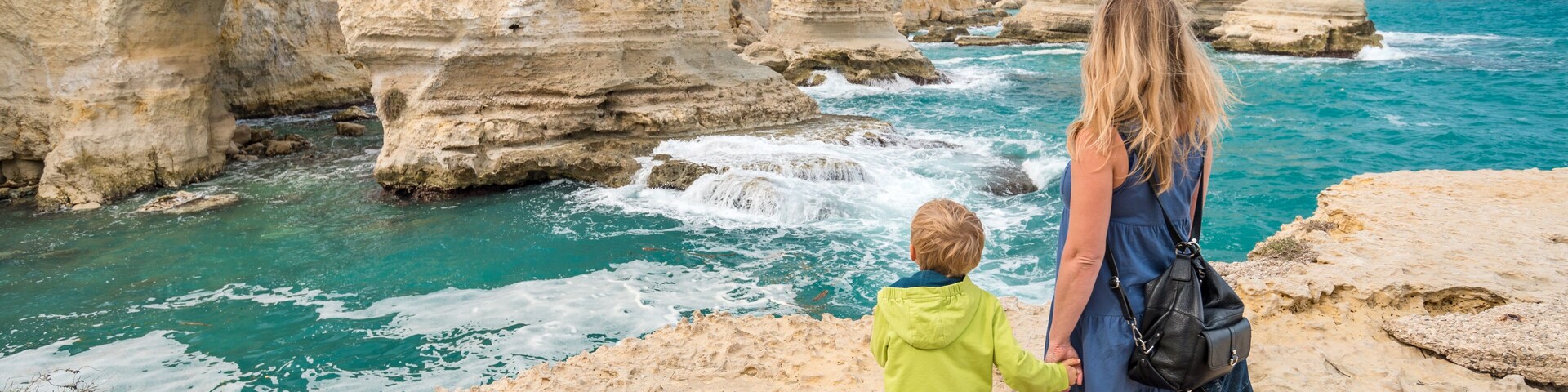 A coastal landscape with rocky cliffs and turquoise sea.