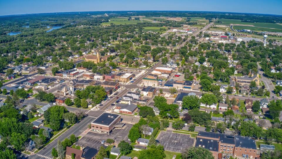 An aerial view of a town with a mix of residential and commercial buildings, a church, and a large water tower.