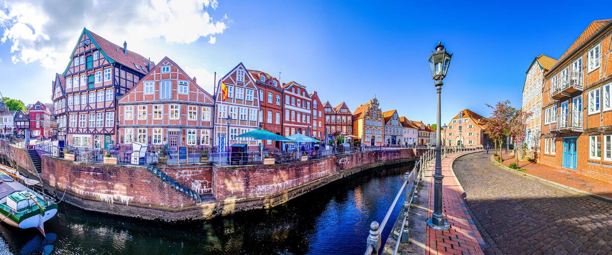 A canal with historic buildings, a boat, and a cobblestone street.
