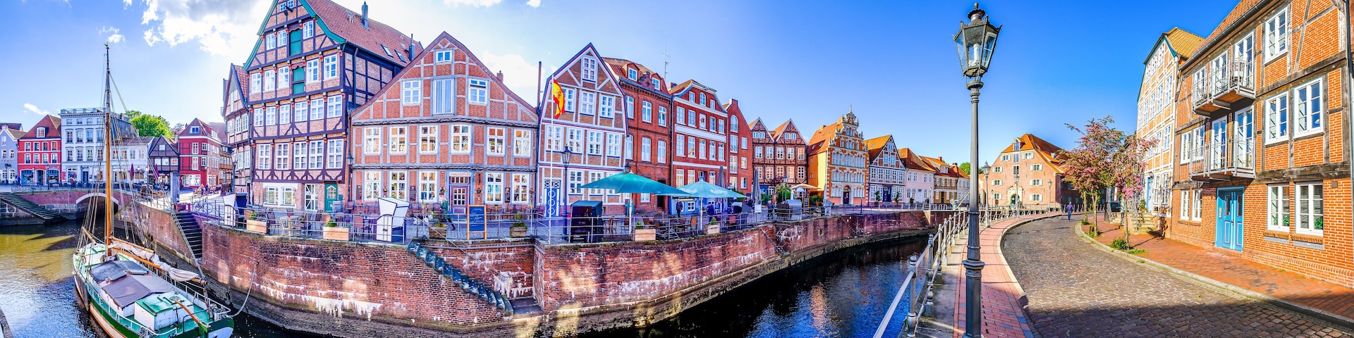 A canal with historic buildings, a boat, and a cobblestone street.