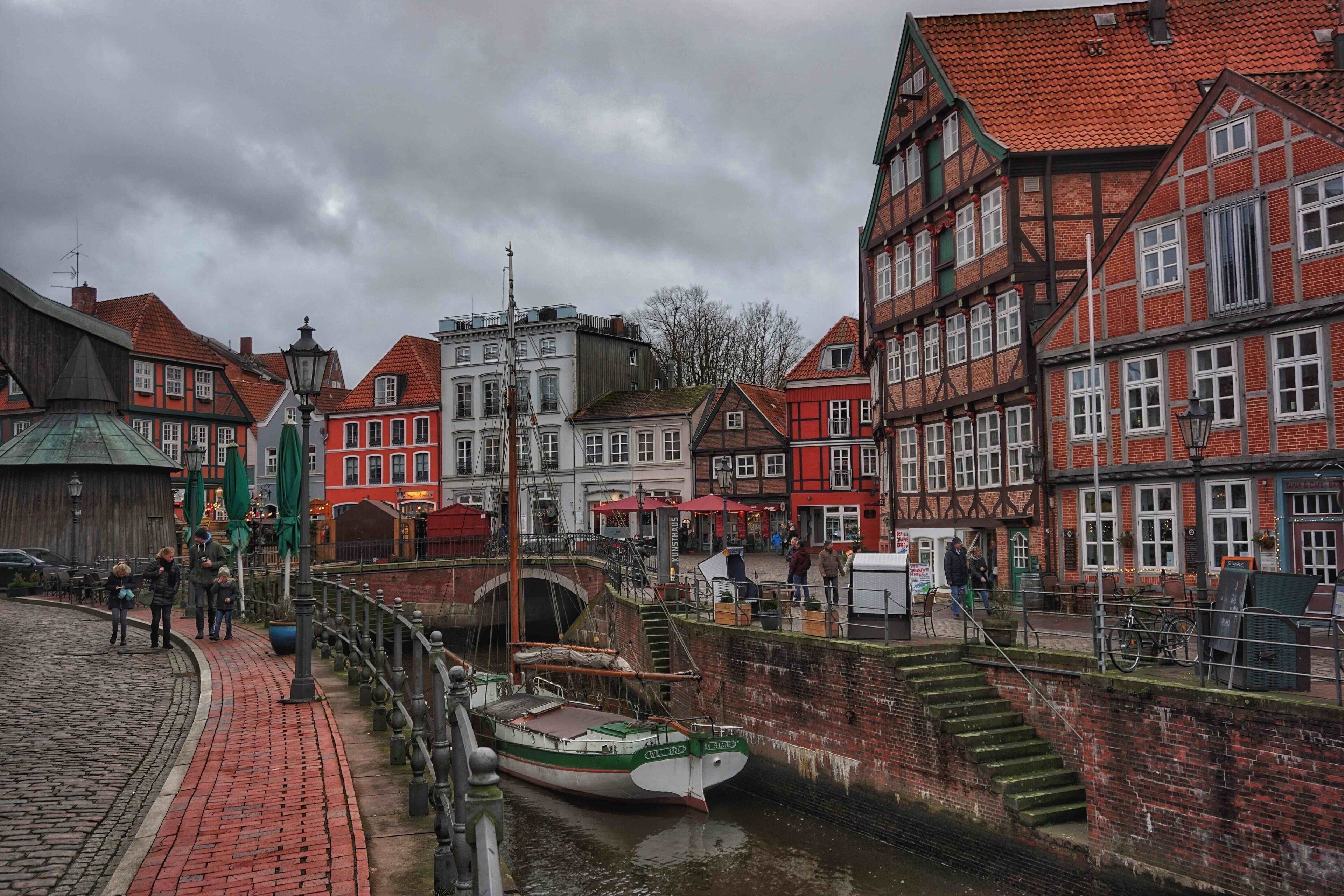 A canal with boats, a bridge, and historic buildings with red and white facades.