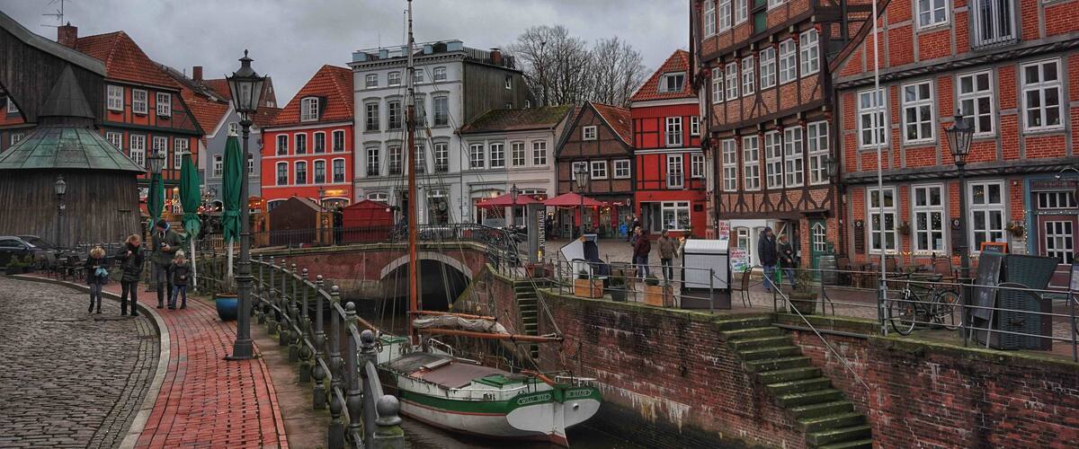 A canal with boats, a bridge, and historic buildings with red and white facades.