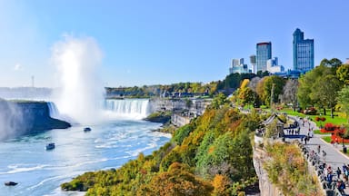 A waterfall, a river, and a cityscape with modern buildings.
