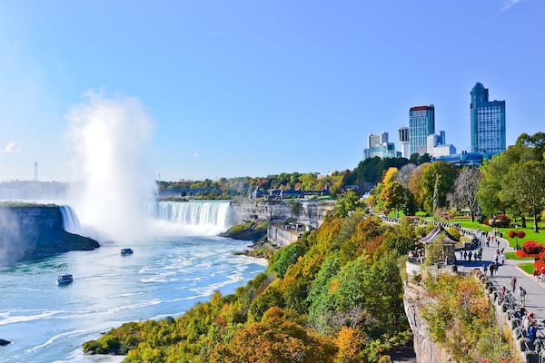 A waterfall, a river, and a cityscape with modern buildings.