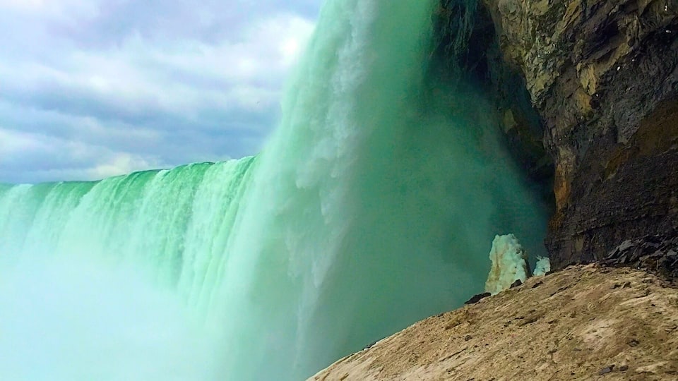 Une grande cascade se déversant en contrebas d’une falaise rocheuse.
