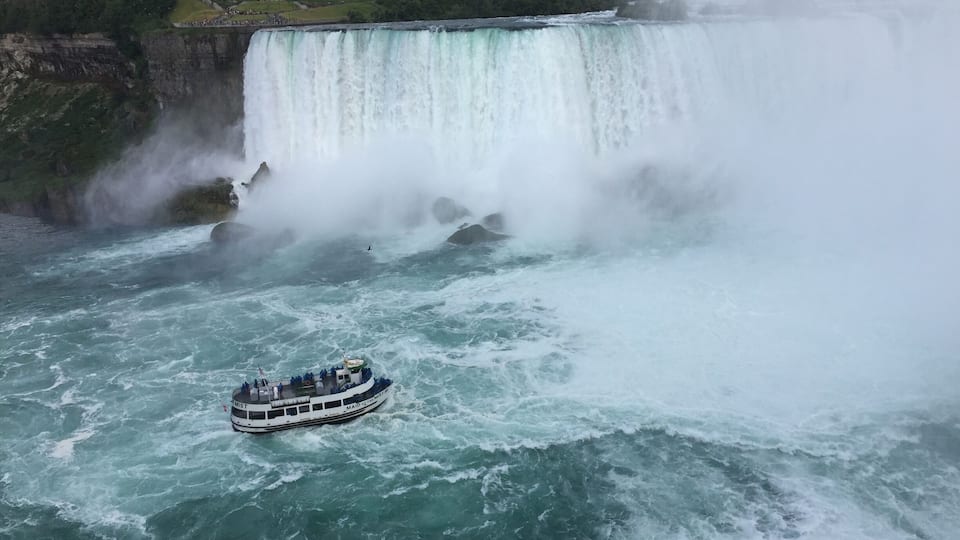 A large waterfall with a boat in the foreground.