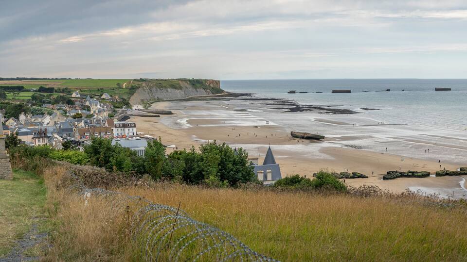 A coastal town with a sandy beach, cliffs, and a church.