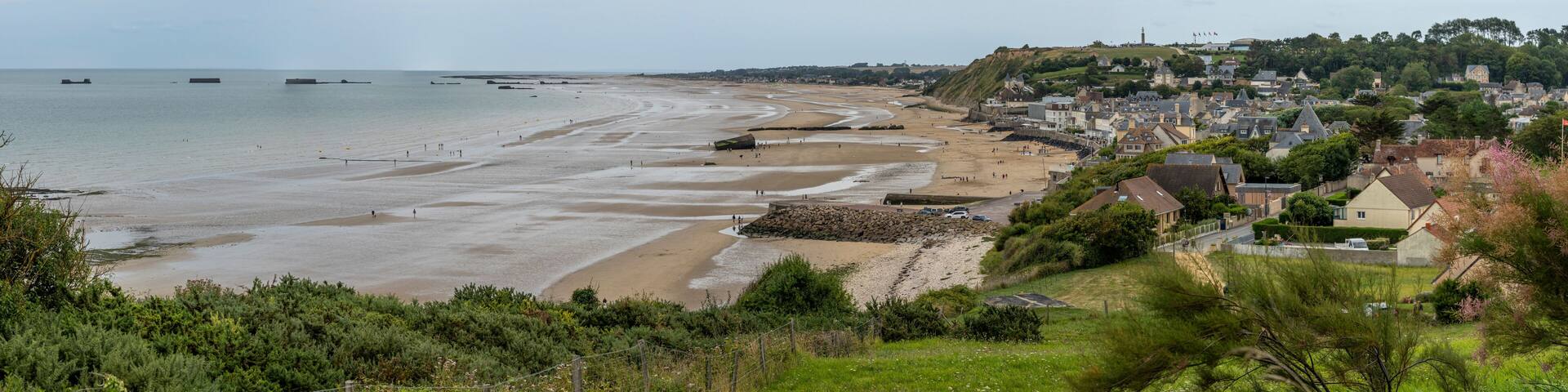 Arromanches-les-Bains, France - 08 08 2025: Normandy landing blockhouse. Panoramic view of the artificial port, the beach, the sea, cliffs and the city