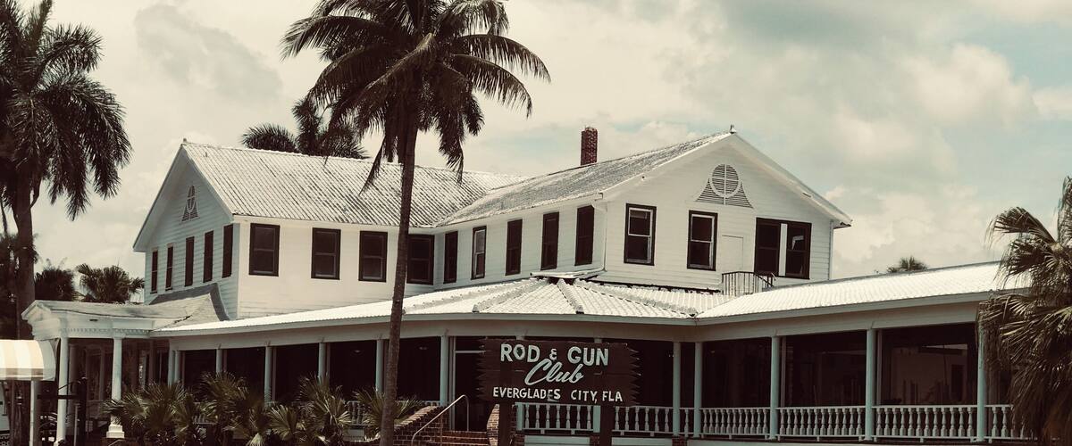 Ein weißes Gebäude mit einem Schild, auf dem 'Rod & Gun Club' steht.