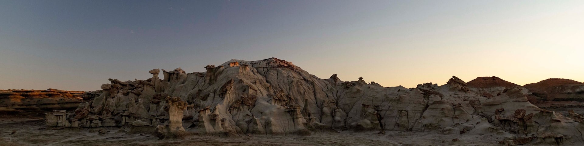 A desert landscape with unique rock formations and a clear sky.