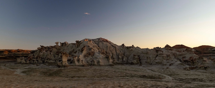 A desert landscape with unique rock formations and a clear sky.