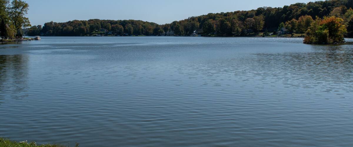 A calm lake with a forested shoreline and a small island.