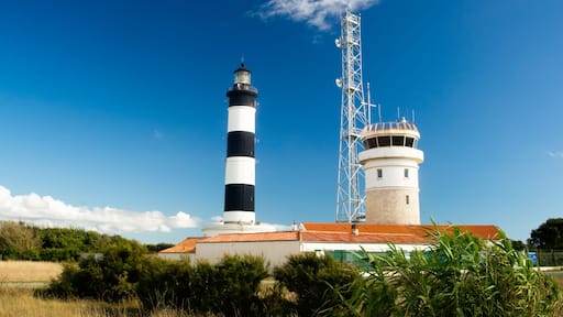 Lighthouse with blue sky and summer clouds and terracotta roof top in chassiron, Oleron Island, France