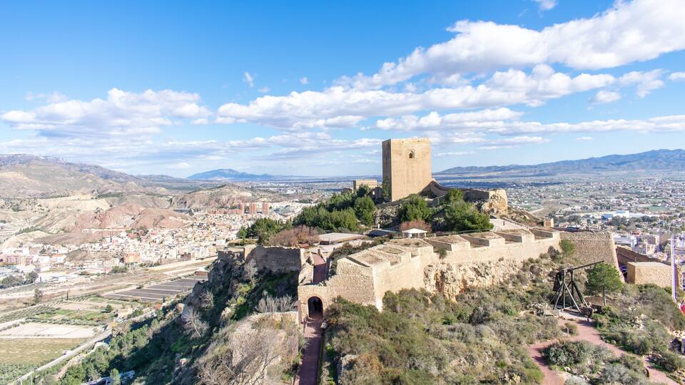 A historic fortress on a hill overlooking a city.