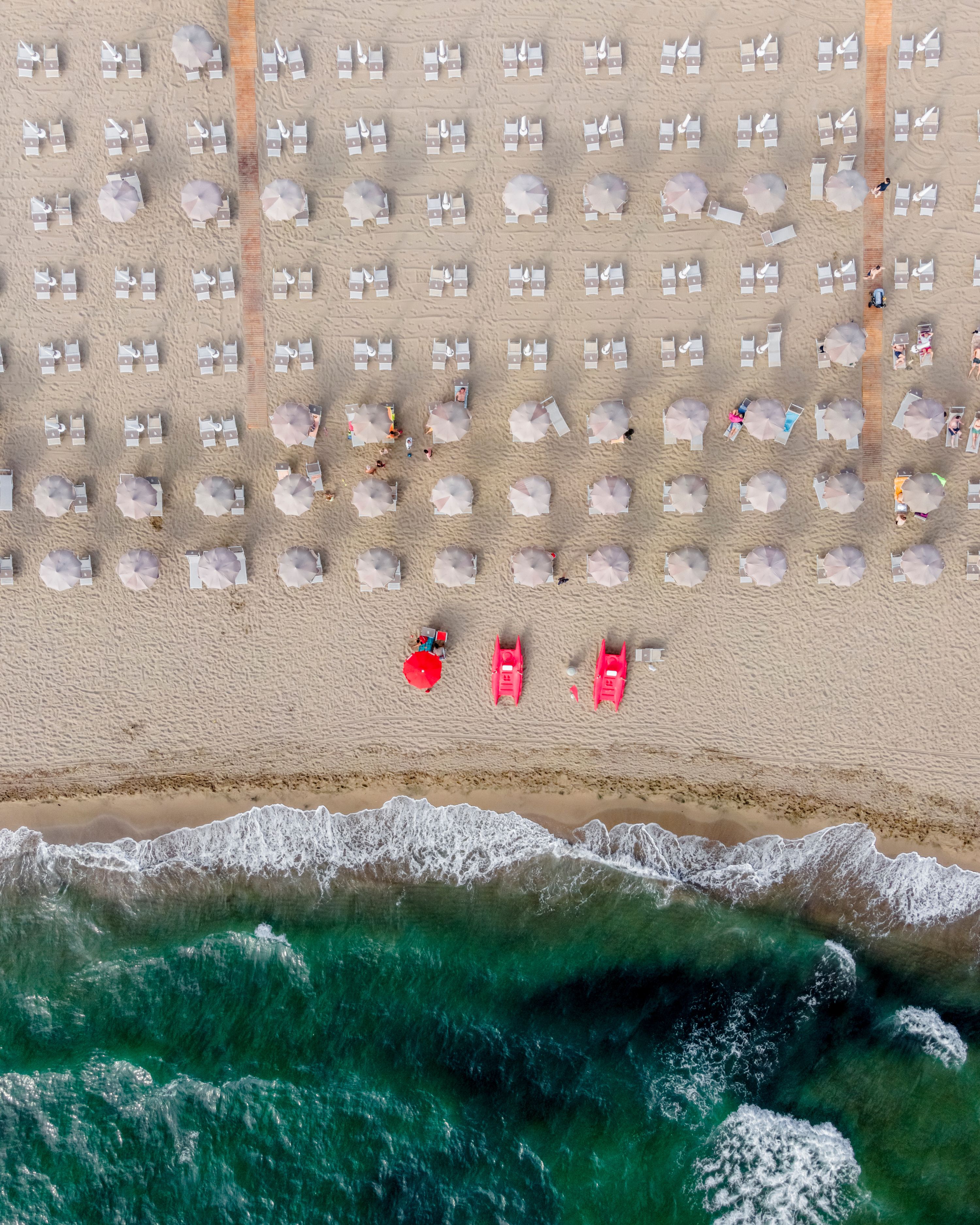 Aerial view of umbrella on the beach along the shoreline facing the Mediterranean Sea, Capaccio, Paestum, Campania, Italy.
