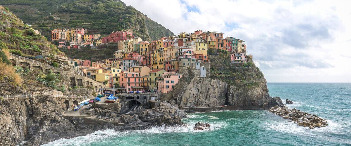 A coastal village with colorful buildings perched on a cliff overlooking the sea.