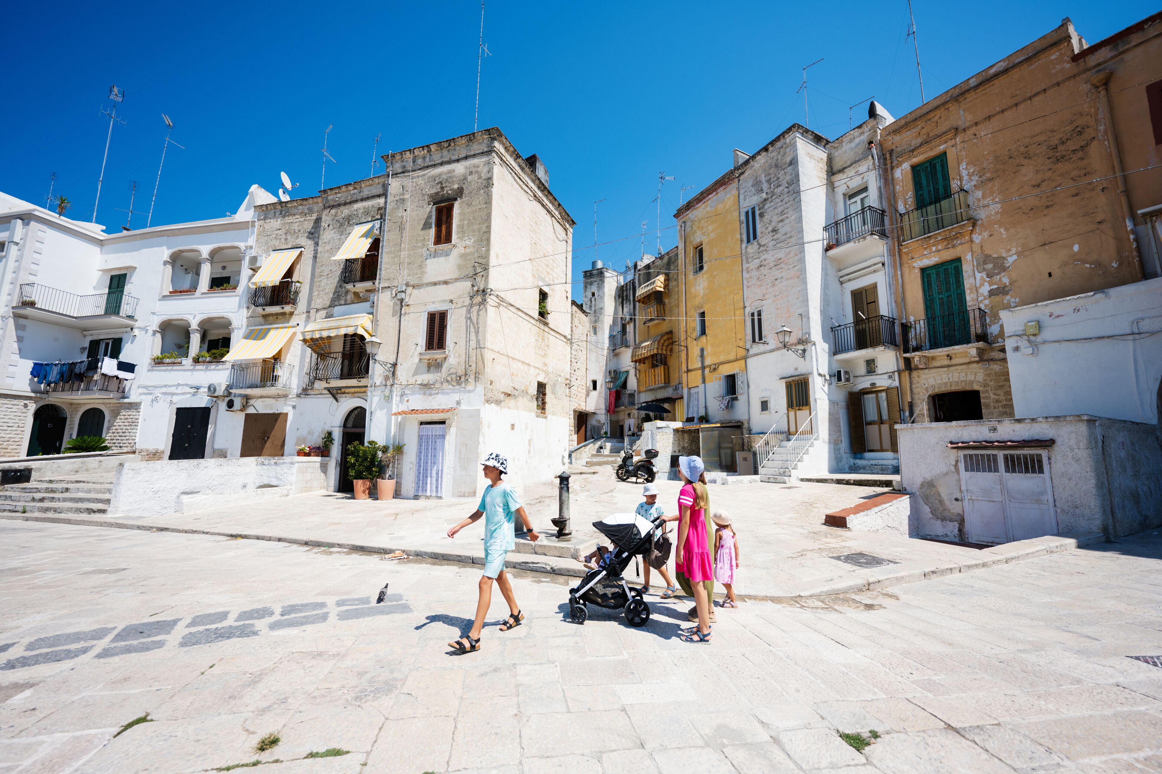 Family of tourists waking in streets Bari, Puglia, South Italy.
