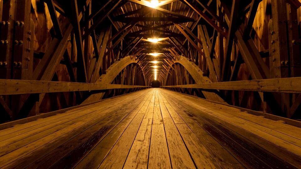 Modern lights brighten the wooden structure of the Blair Covered Bridge in Campton, New Hampshire