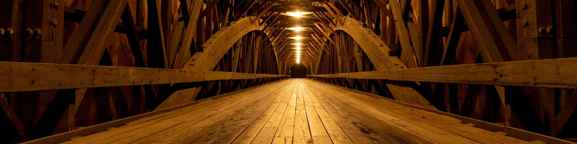 Modern lights brighten the wooden structure of the Blair Covered Bridge in Campton, New Hampshire