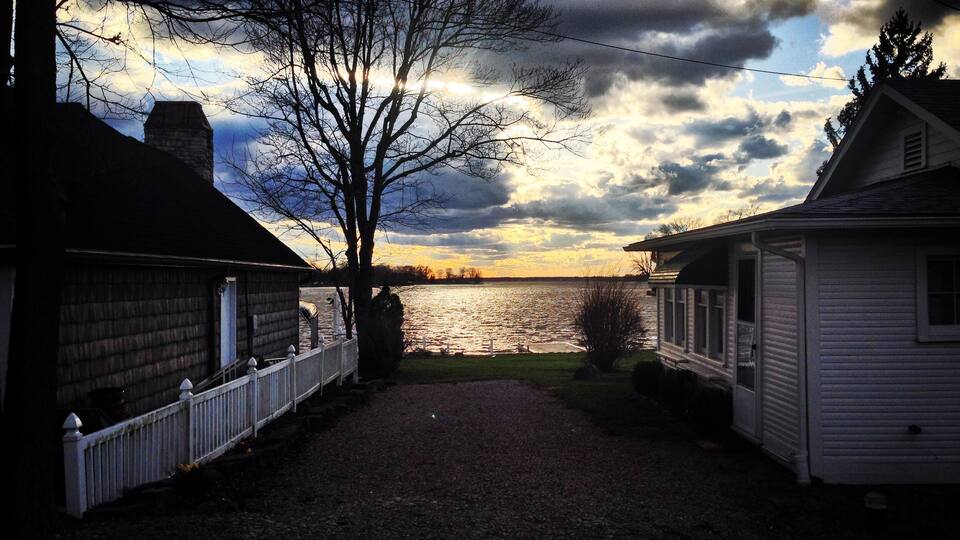 A gravel path leading to a lake with houses on either side.