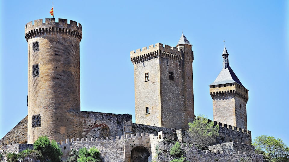 A medieval castle with three prominent towers and a fortified wall.